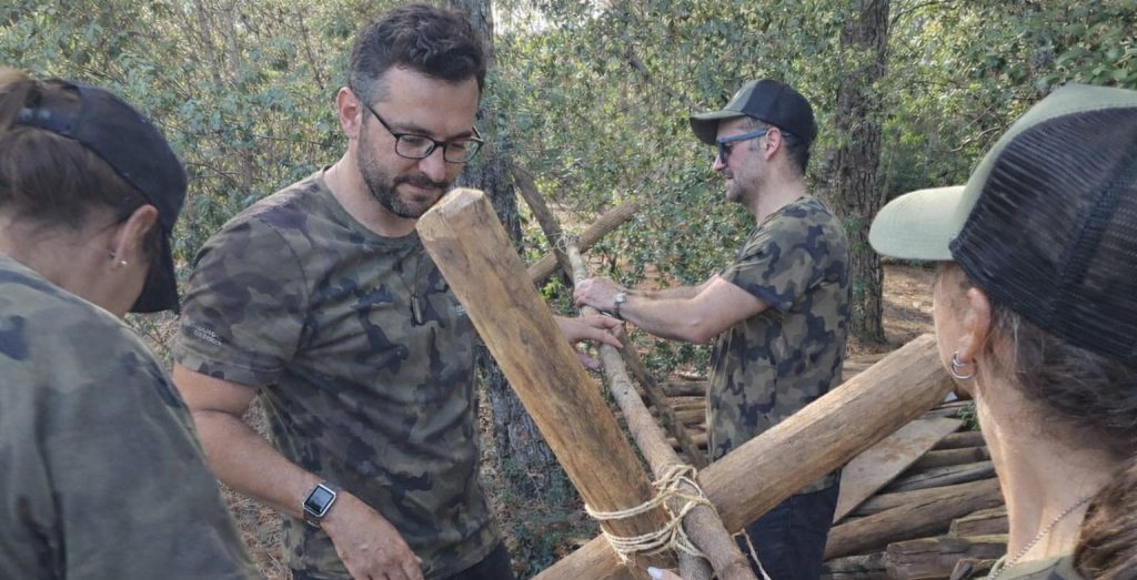 Dinâmica de team building com construção em equipa em ambiente natural